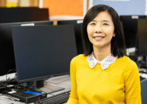 NIU ETRA professor Dr. Hsu sits in front of a computer.